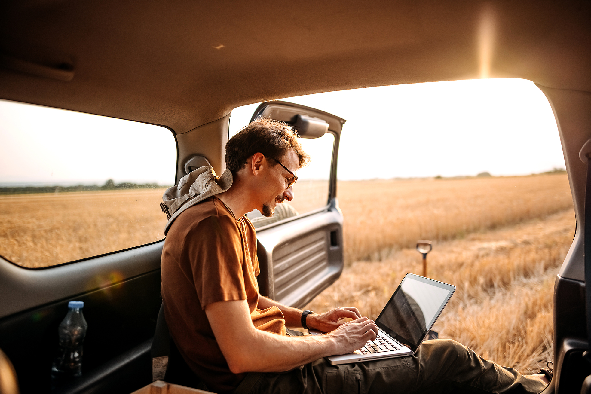 Man working on laptop inside vehicle