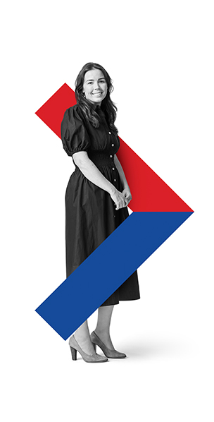 Woman standing and smiling while holding her hand
