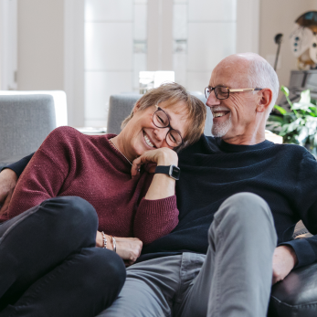Elderly couple relaxing on a cozy living room couch